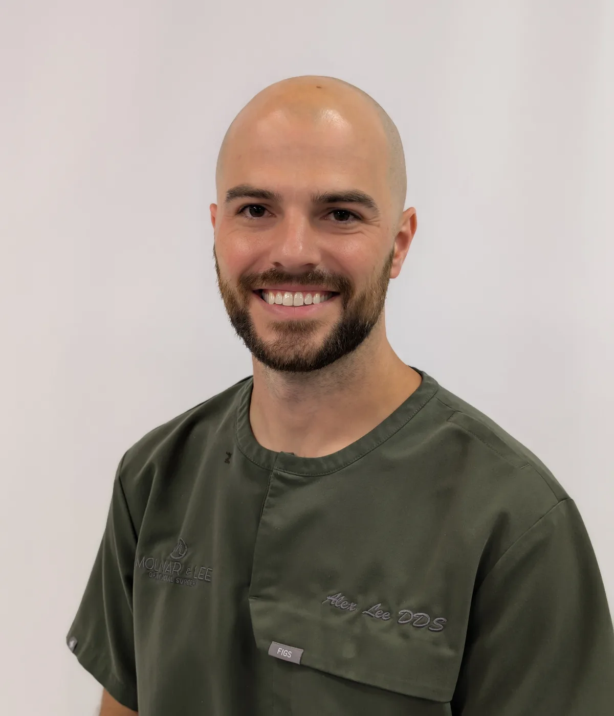 Dr. Alex Lee smiling in green Molnar & Lee scrubs